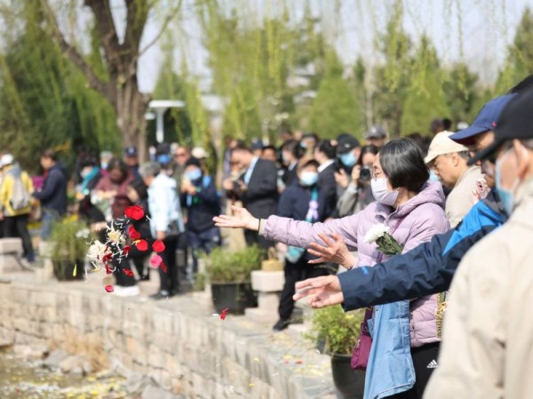 4月2日，北京举行生态葬清明公祭。家属撒下花瓣寄托对亲人的哀思。新京报记者 王贵彬 摄