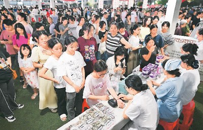 8月15日，在江西省抚州市东乡区体育场开展的“中医药文化健康夜市”活动现场，一缕缕中药香、一杯杯茶饮、一项项中医特色疗法吸引了众多市民驻足。何江华摄（人民视觉）