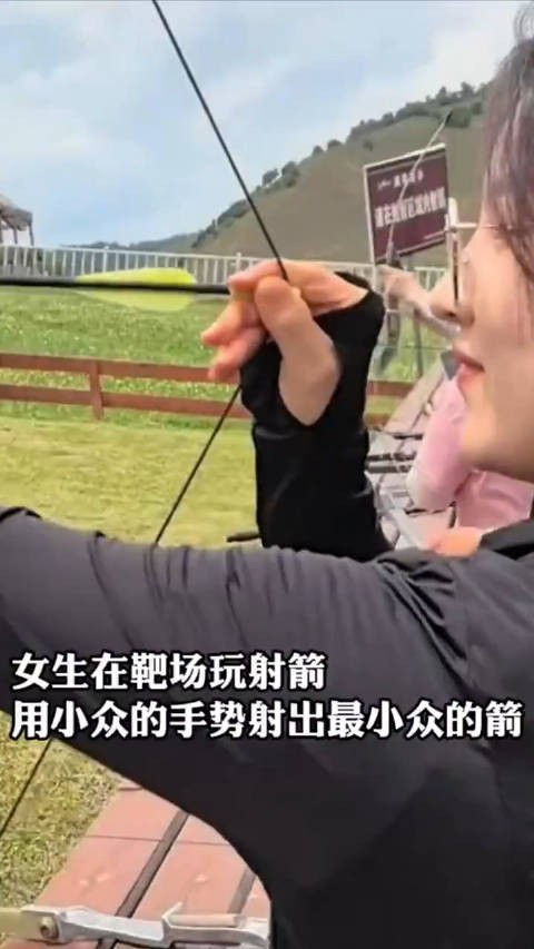 女生在靶场玩射箭用小众的手势射出小众的箭