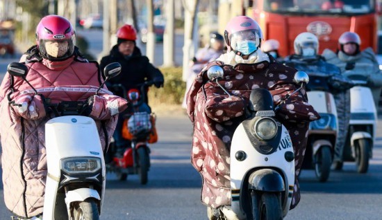 2月8日，在江苏省淮安市淮安区，市民骑车出行。受寒潮影响，多地迎来大风降温天气。新华社发（赵启瑞摄）