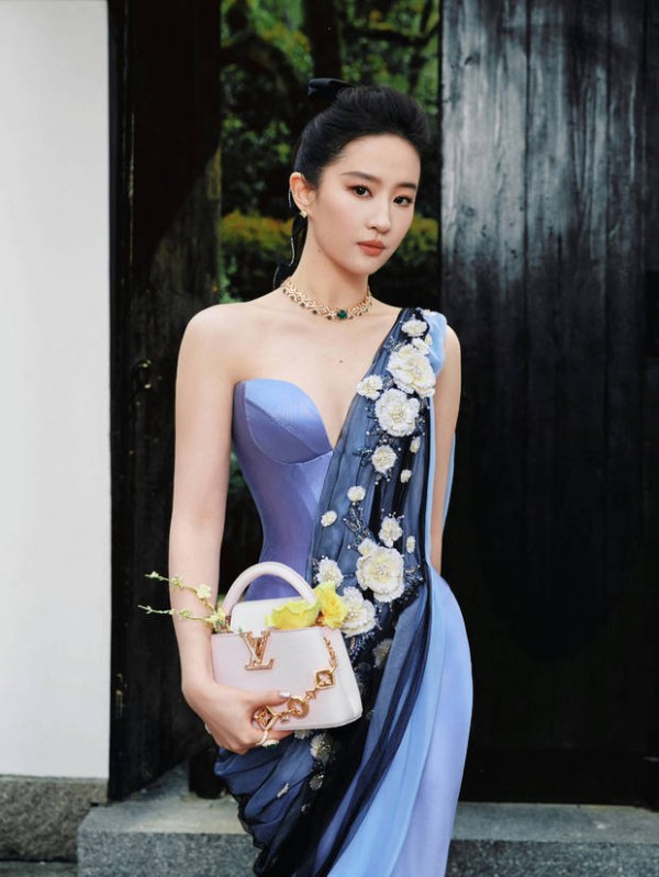 搜狐娱乐讯 3月31日，刘亦菲在个人社交账号晒出了一组她今晚活动的造型图，身穿蓝色丝缎礼裙，婀娜多姿。