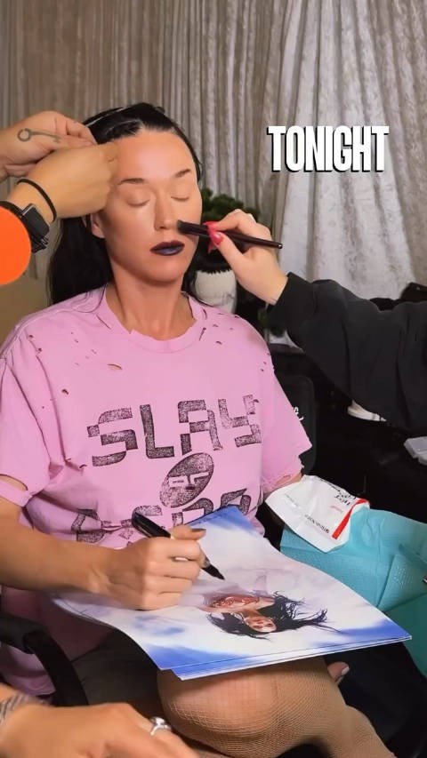 就写 Katy Perry 在后台为今夜首场巡演舞台准备期间亲签海报