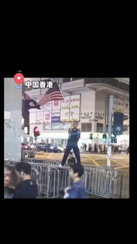 一男子在香港街头高举挥舞英美国旗，被愤怒的市民一脚踹倒