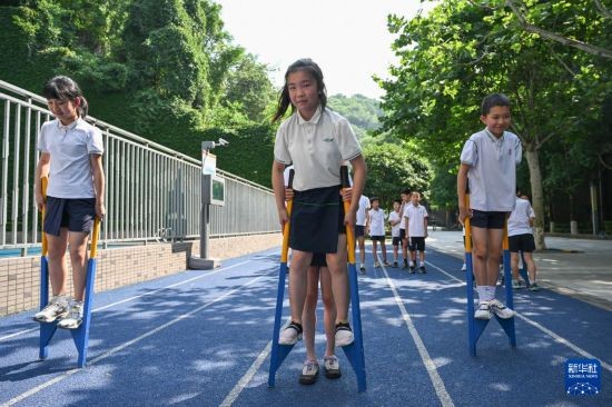 5月19日，重庆市渝中区天地人和街小学，同学们参加踩高跷大课间活动。新华社记者 陈诚 摄