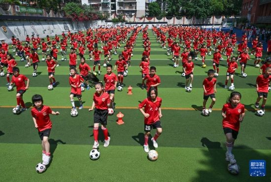 5月19日，重庆市大田湾小学，同学们参加足球大课间活动。新华社记者 陈诚 摄