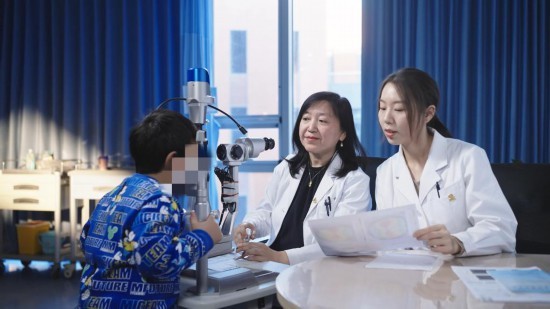 北京大学第一医院眼科主任冯云（右二）正在为患儿进行视力检查。（北京大学第一医院供图）