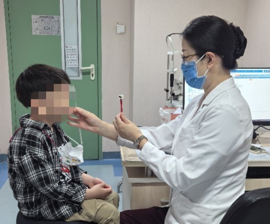 北京大学第一医院眼科副主任刘海华正在为患儿进行斜视检查。（北京大学第一医院供图）