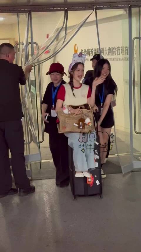 欧阳娜娜就自动水灵灵的坐在行李箱上让工作人员推着走