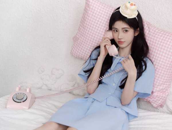鞠婧祎靠在粉色枕头上打电话，少女感十足。