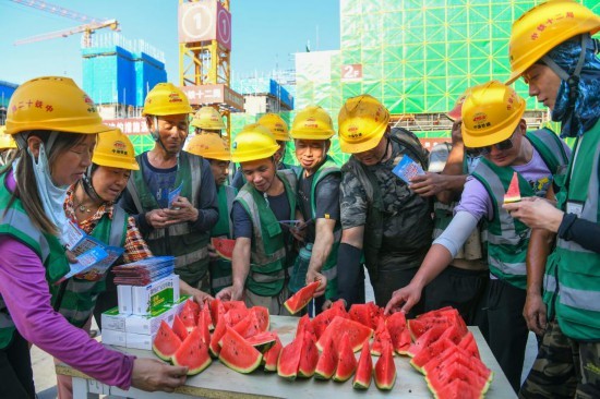 6月11日，在河北雄安新区启动区西北片区小学项目建设现场，中铁十二局工人吃西瓜解暑。新华社记者 牟宇 摄