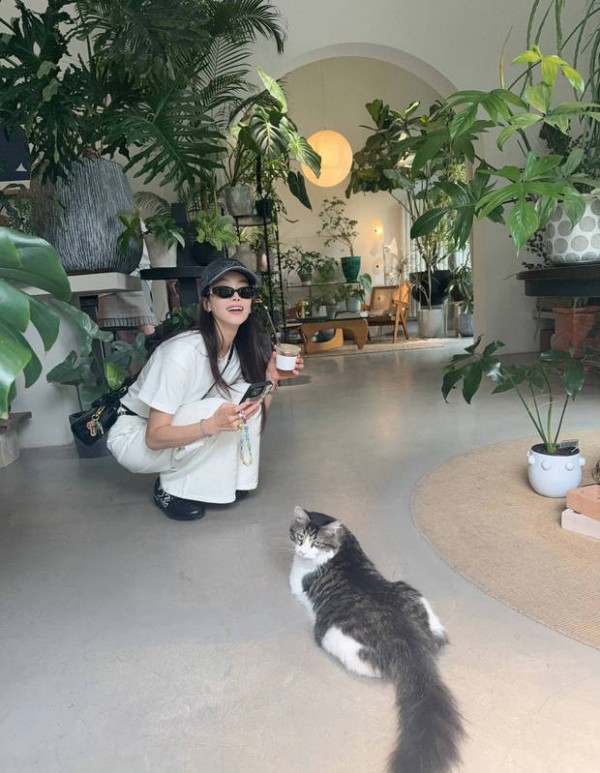 宋茜蹲在地上给猫咪拍照。