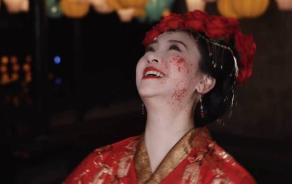 翁虹开怀大笑，搭配脸上的血迹，笑容邪魅，有种鬼新娘的感觉。