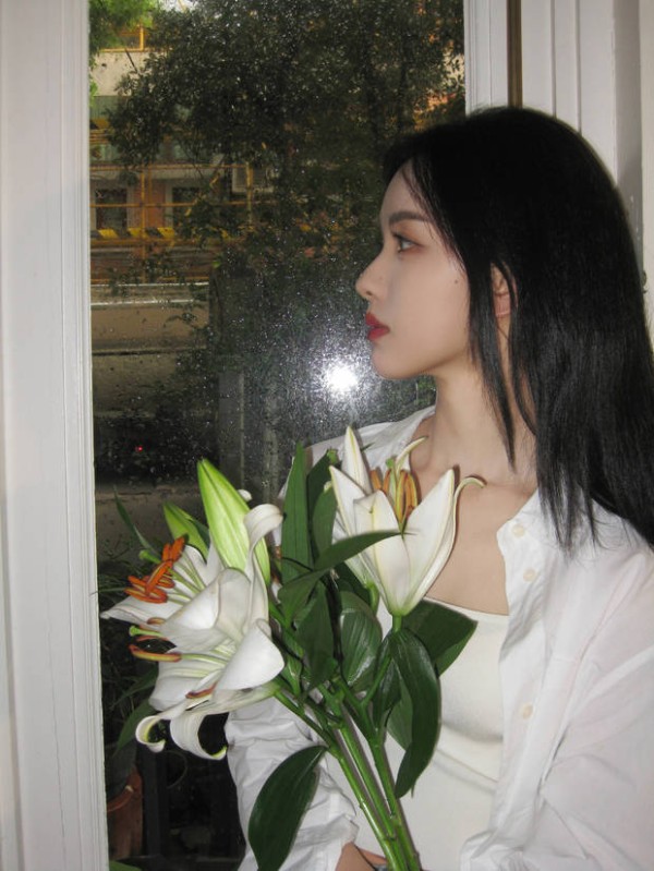 陈都灵手拿鲜花拍照，人比花娇。