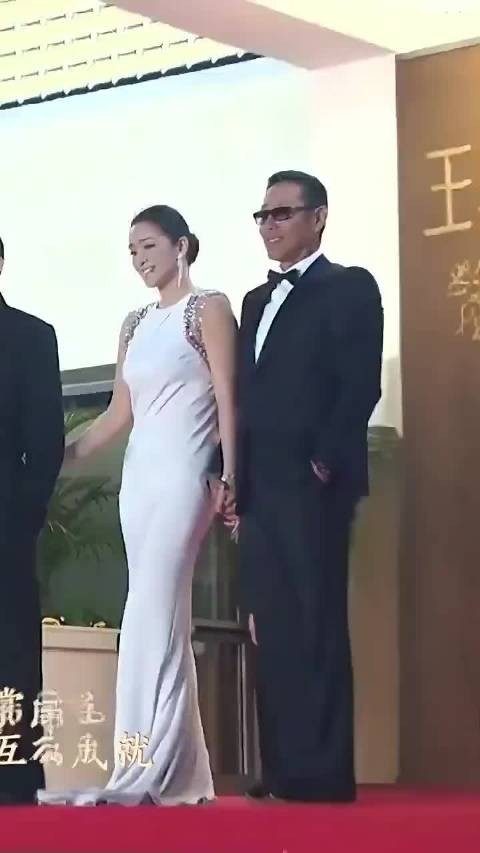 此刻的巩俐确实像女王，众多男人捧着她，愿意做她的护花使者
