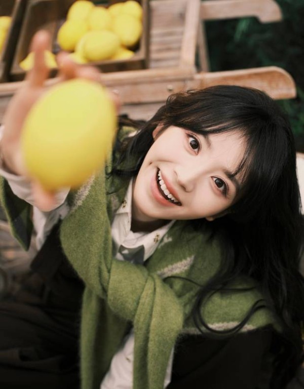 田曦薇手拿柠檬，笑容明媚。