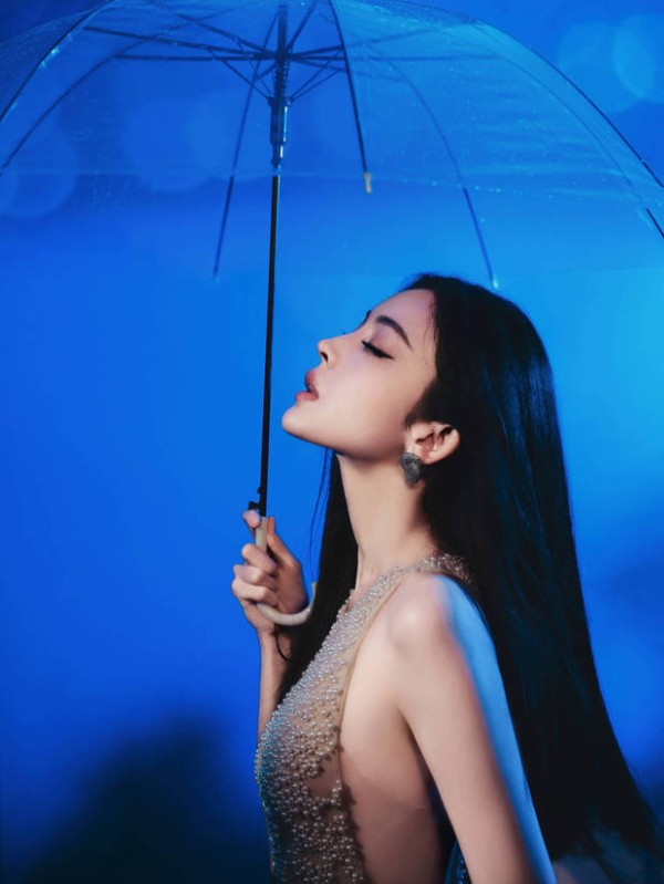 娜扎闭眼撑伞,颇具氛围感。
