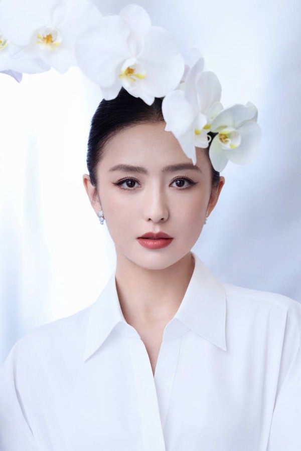 佟丽娅妆容精致,头顶兰花。