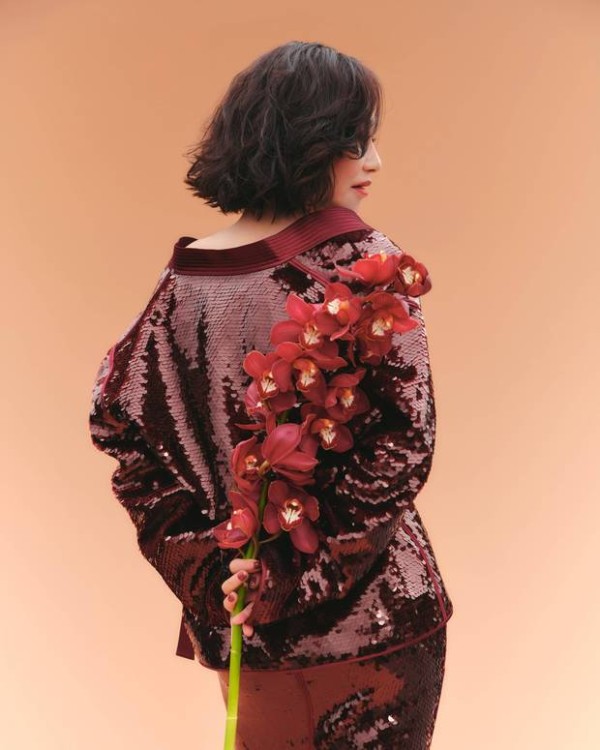 惠英红手持红花，背影窈窕。