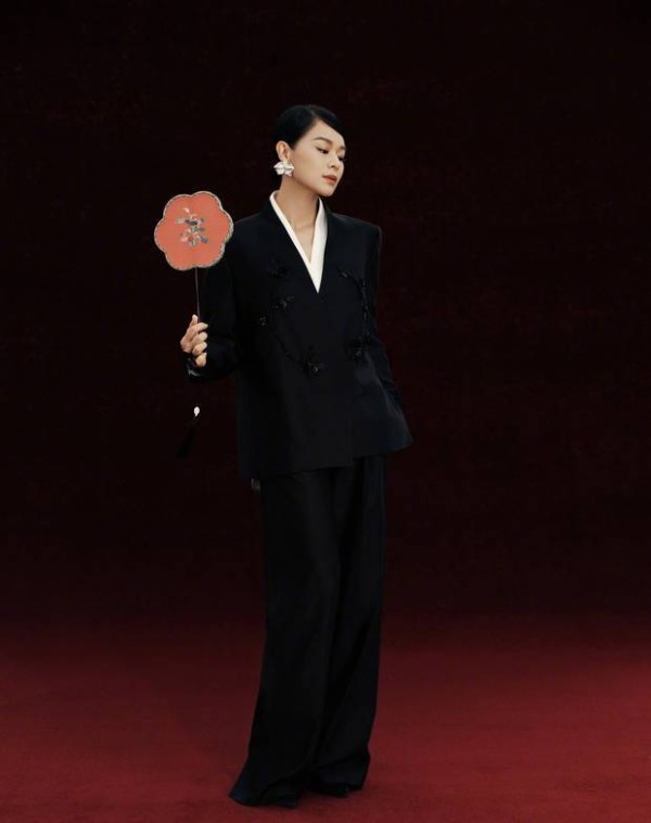 胡杏儿拿着团扇，姿态优雅。