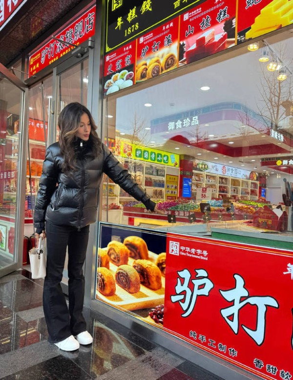 谷爱凌在糕点铺前拍照留念。