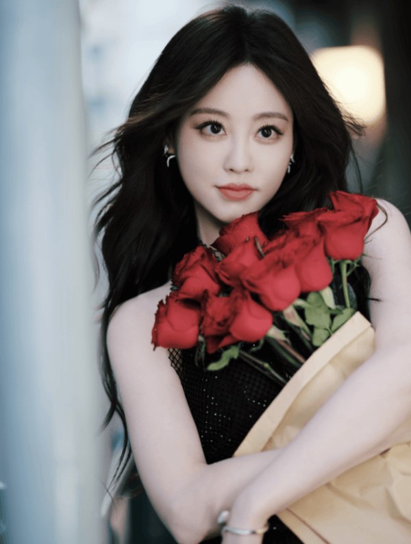 祝绪丹怀抱簇簇红玫瑰,黑色吊带裙衬得肤白明艳。