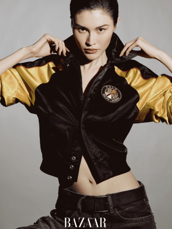 何穗身着黑黄拼接款外套亮相，抬手调整衣领的姿态干练利落。