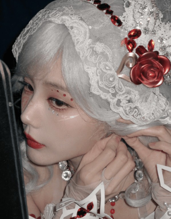 李一桐侧颜出镜，耳饰细节与白发蕾丝装扮呼应，红玫瑰装饰点缀其间。