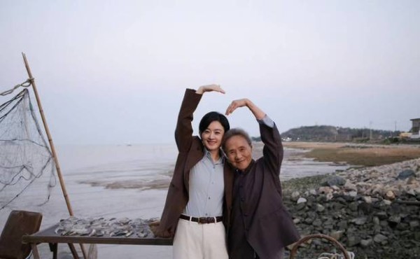 二人抬手比心，笑容灿烂。