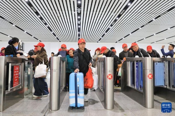 2月22日,乘坐返岗务工专列的务工人员及家属从凯里南站检票进站。新华社发(王波摄)