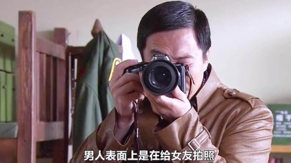 男人假装给女友拍照,实际上是在拍墙上的边境布防图