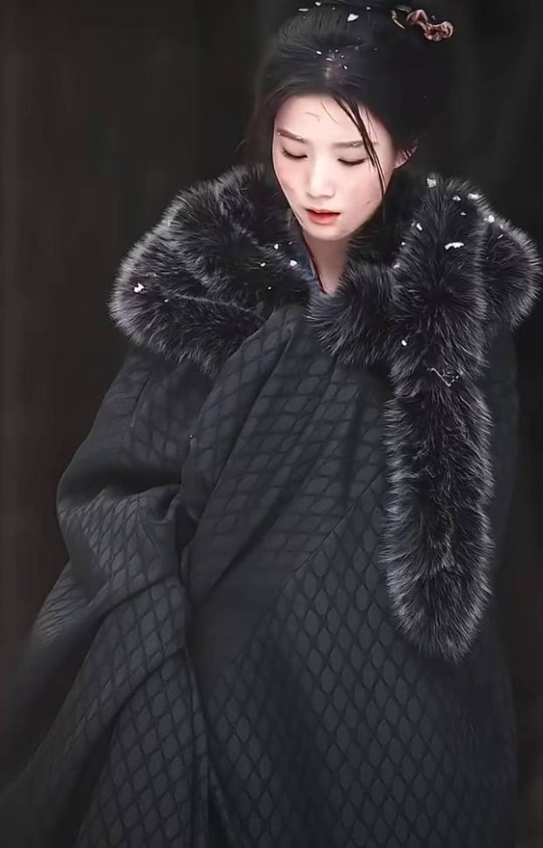 卢昱晓披黑斗篷，低头敛眉。