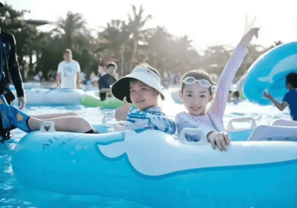 小酒窝和朵朵坐充气艇,笑容灿烂。