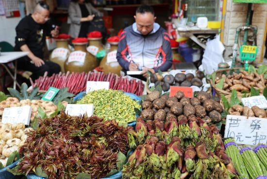 云南省昆明市大观篆新农贸市场，商家在写标价。新华社发（梁志强 摄）