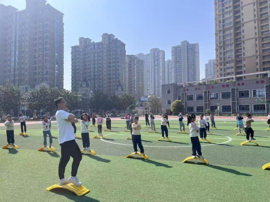南昌市珠市学校云飞路校区的体育课上，学生们在操场上跟着老师进行平衡性训练。受访单位供图