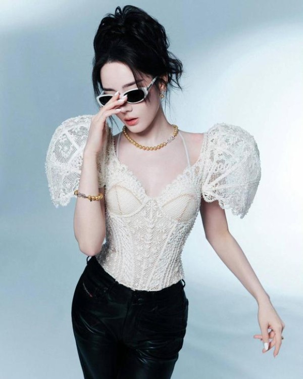 迪丽热巴手轻扶墨镜,珍珠项链与蕾丝衫呼应,,尽显摩登女郎风范。