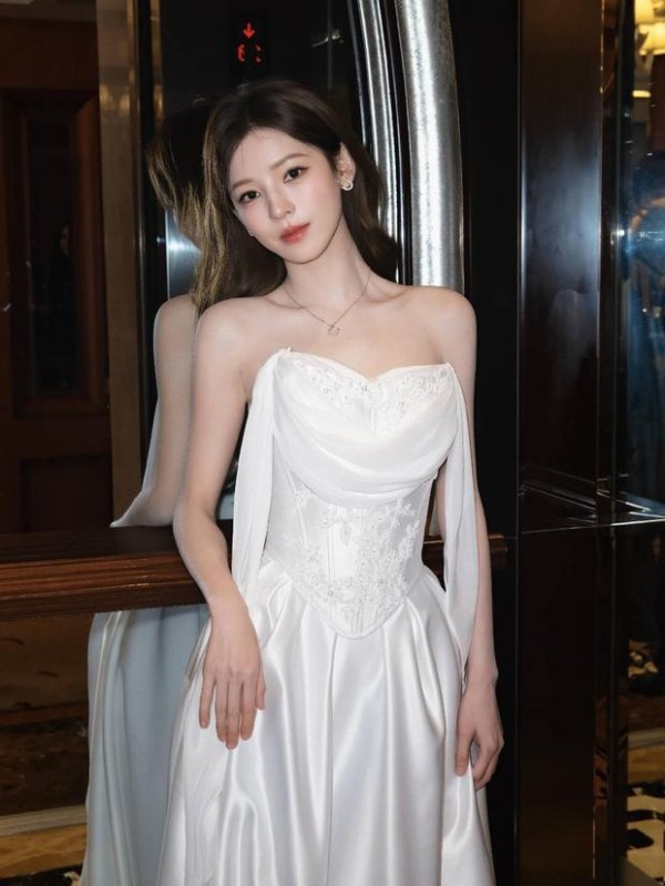 张予曦轻撩发丝眼神温柔,颈间细钻点缀,白裙衬得气质温婉又高级。