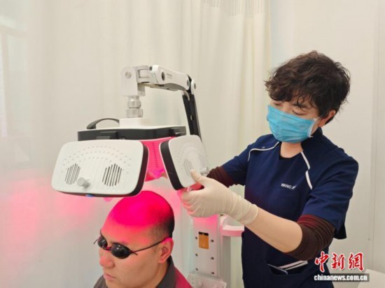 图为患者在西安市红会医院治疗脱发。党田野 摄