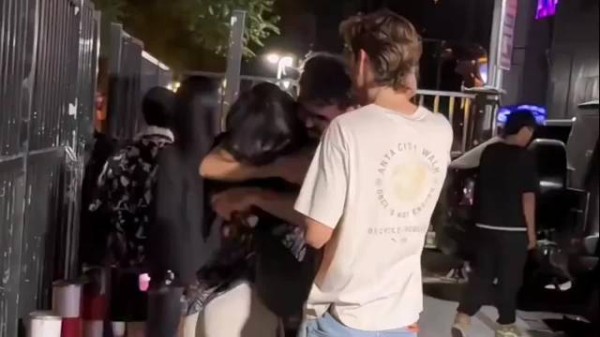 女生夜晚街头与外国友人亲密互动