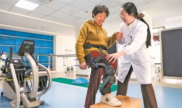 患者在治疗师指导下穿戴外骨骼机器人进行康复训练。 新华社发（顾彬斌摄）